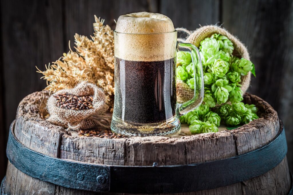 Pint of dark beer with big foam. Brewing industry.